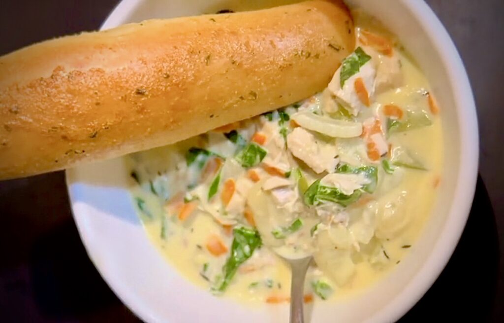 bowl of chicken gnocchi soup with breadstick